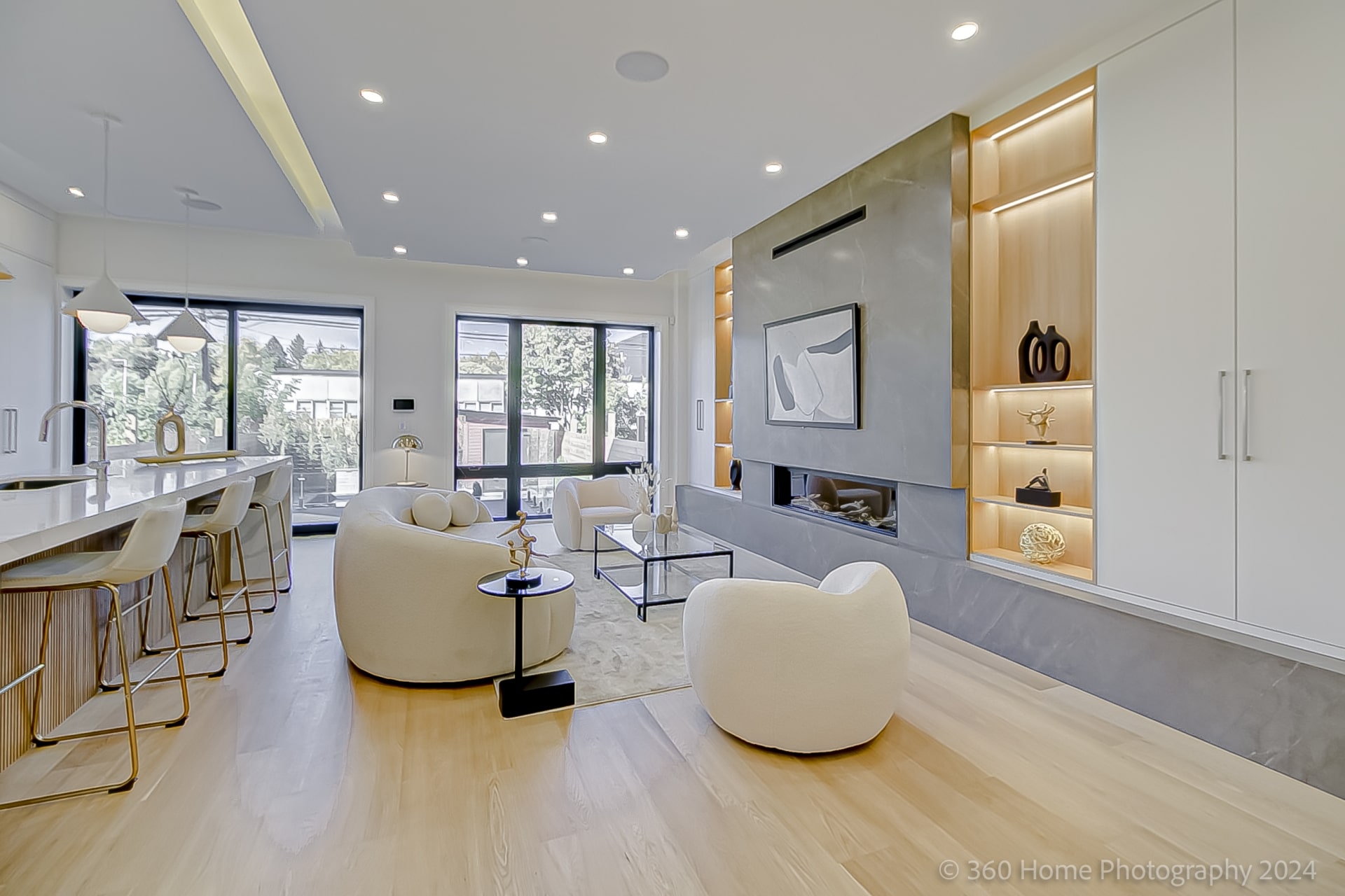 Living room with grey porcelain linear fireplace surround and illuminated oak shelving at 100 Glenvale Blvd