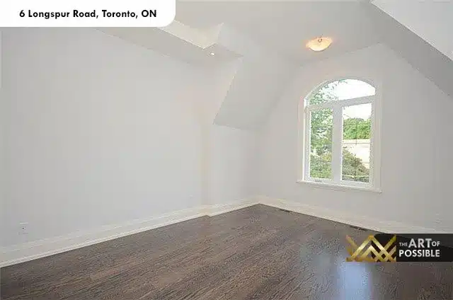 Second vaulted-ceiling bedroom with arched window and dark hardwood floors at 6 Longspur Rd Toronto