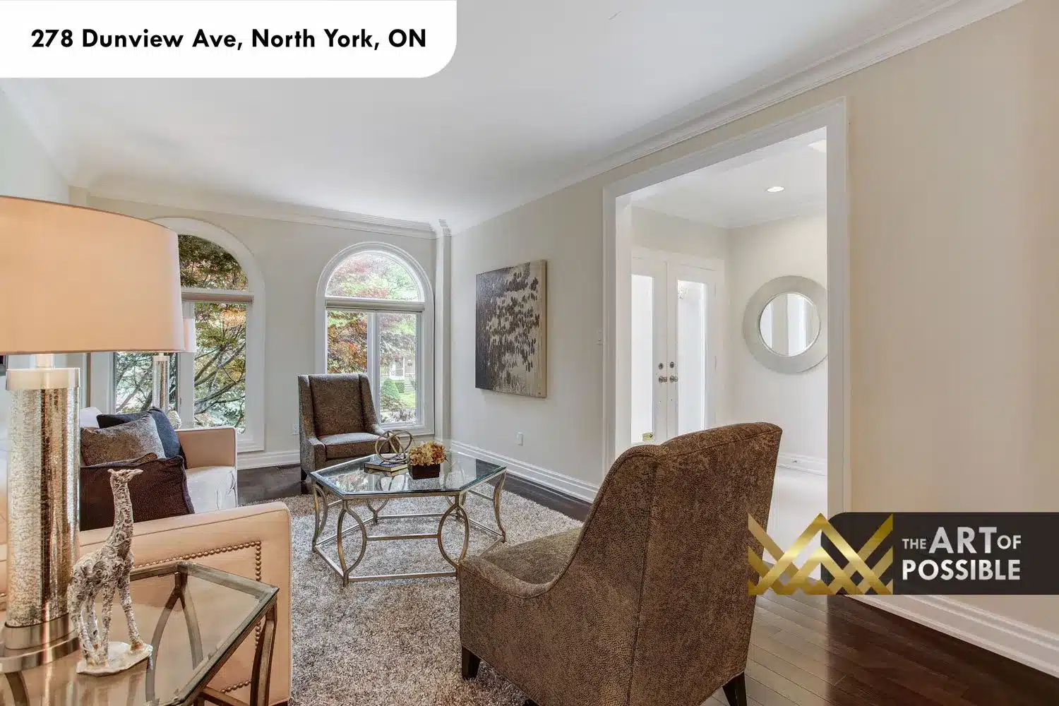 Living room looking toward the foyer, arched window and hardwood floors