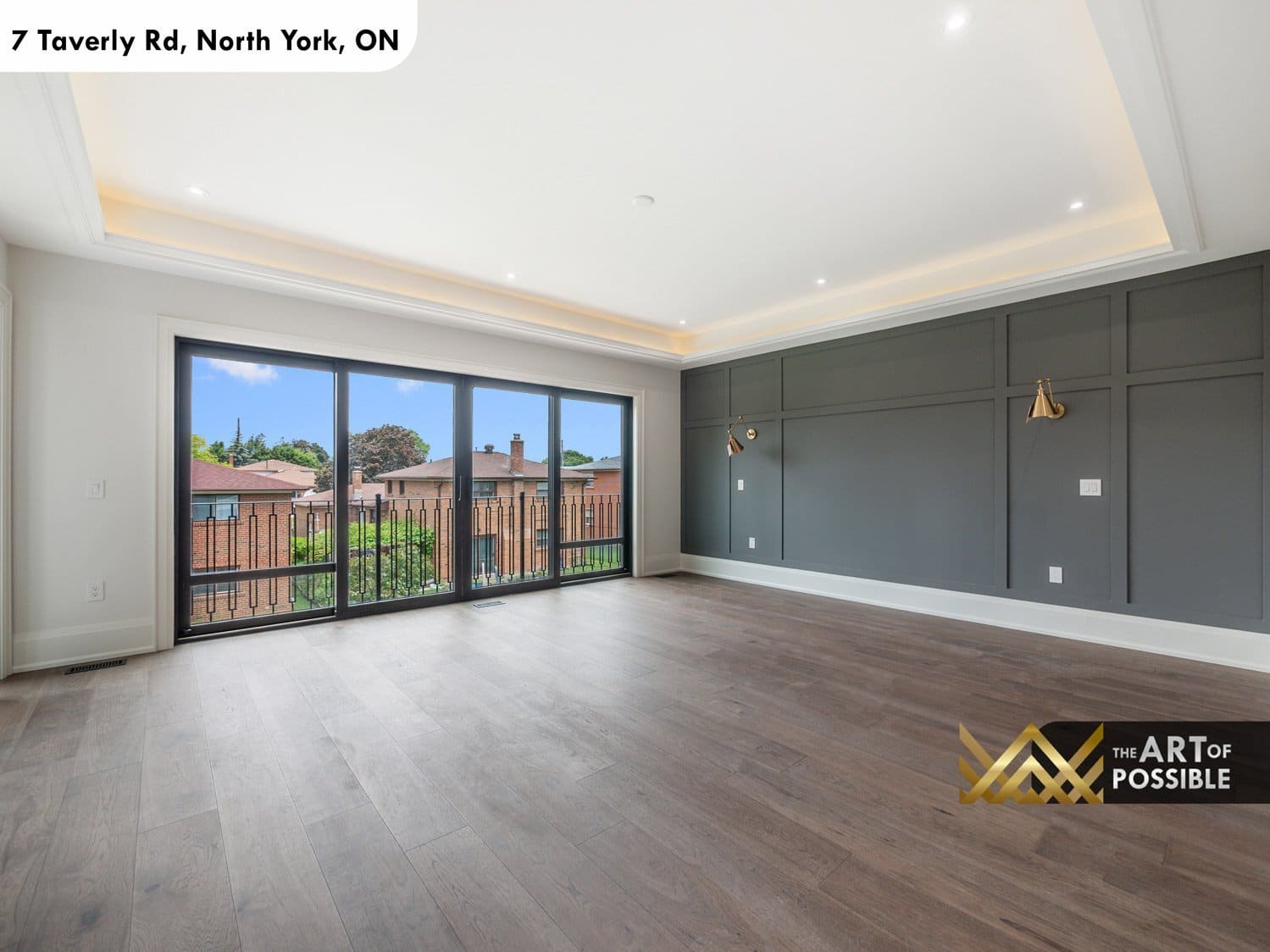 Primary bedroom with charcoal feature wall, brass sconces and balcony access