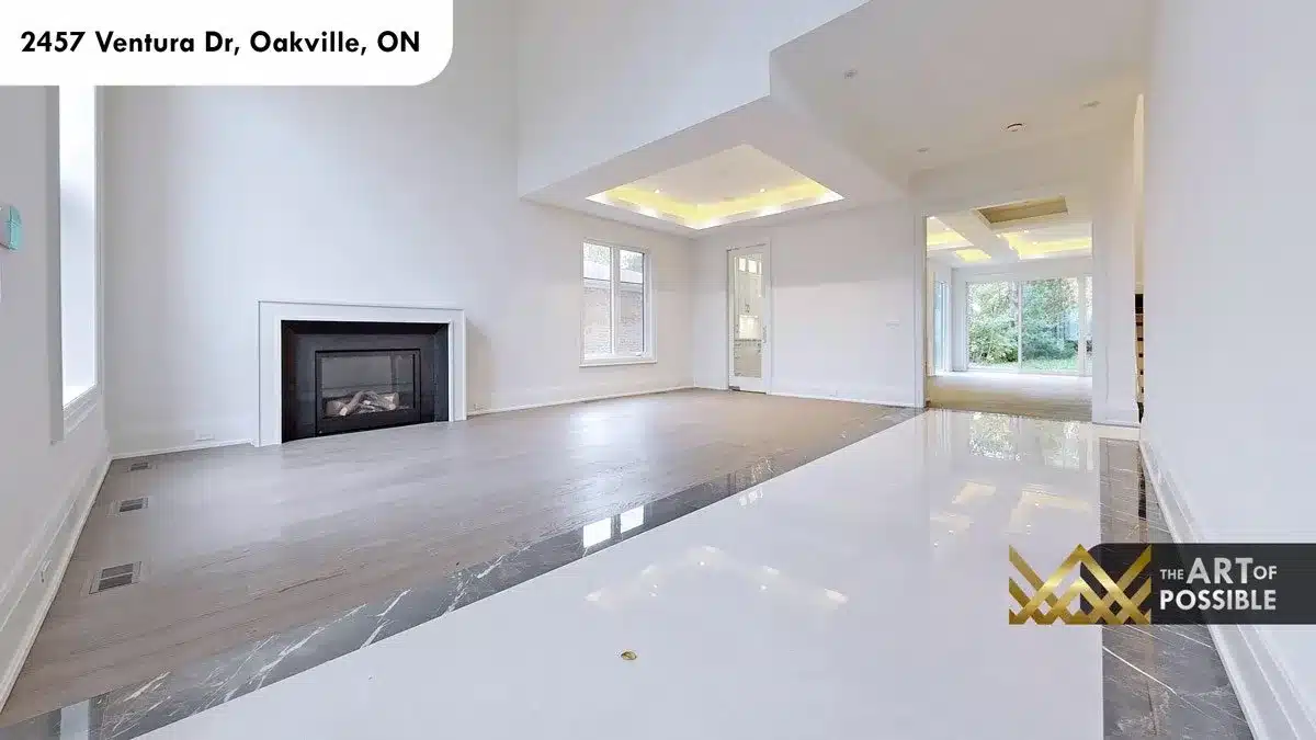 Open-plan living room with white fireplace surround LED cove tray ceiling and wide plank hardwood floors