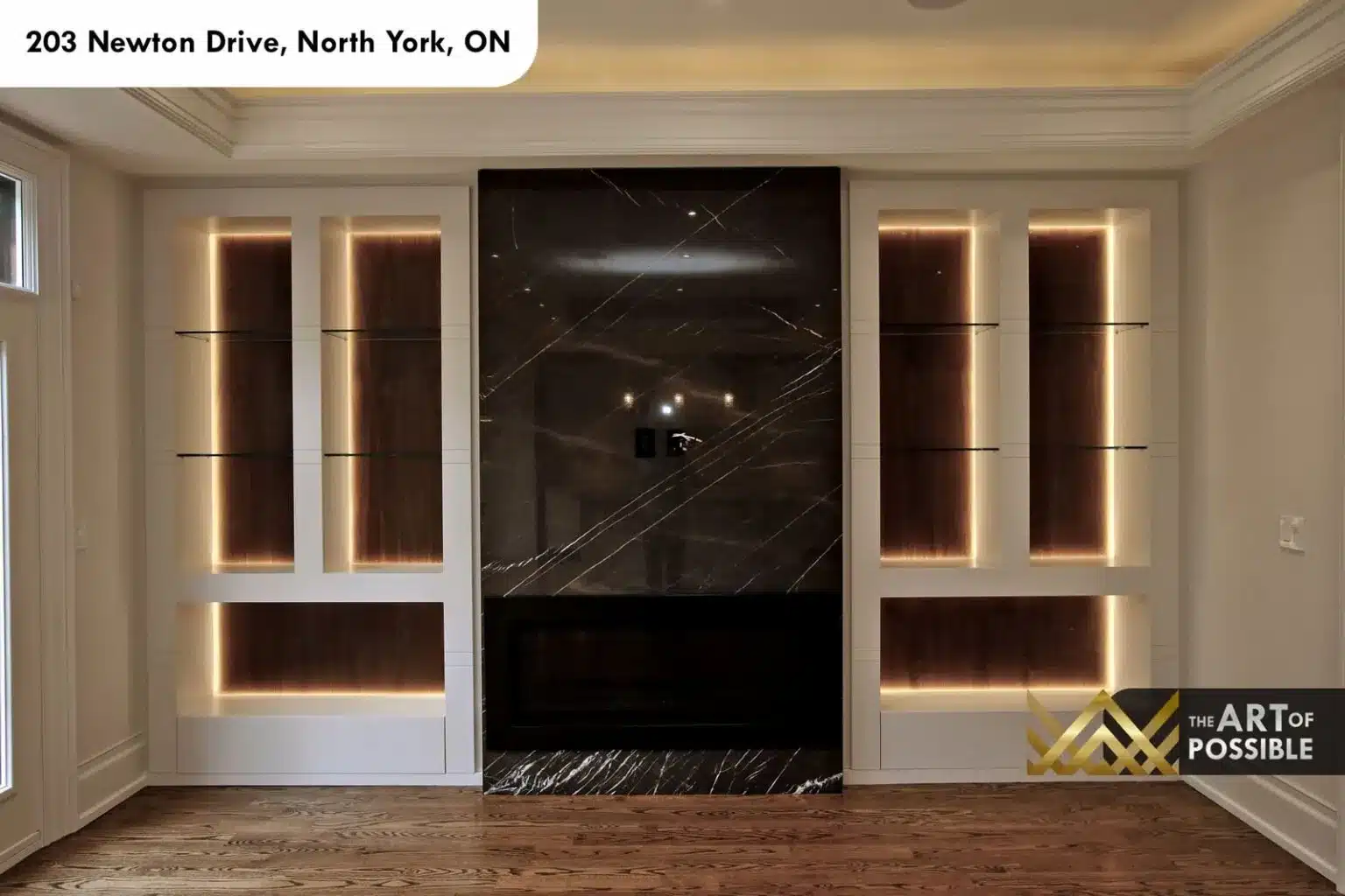 Family room opening to the staircase with marble fireplace and glass shelving