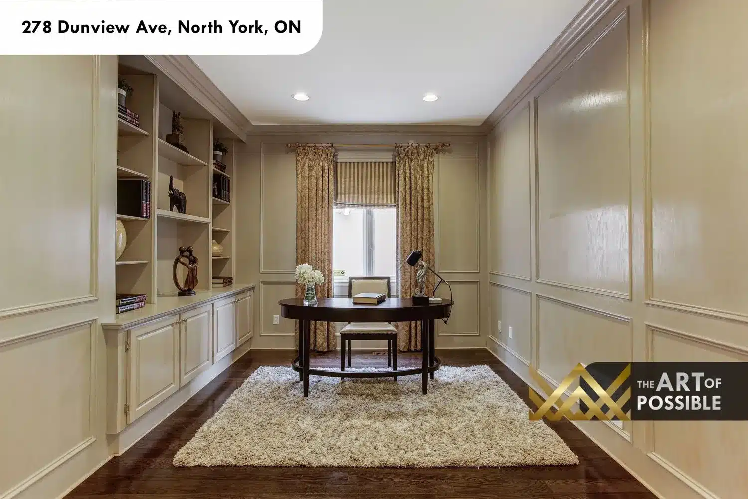 Main floor home office with custom built-in shelving, wainscoting panel moulding and dark hardwood