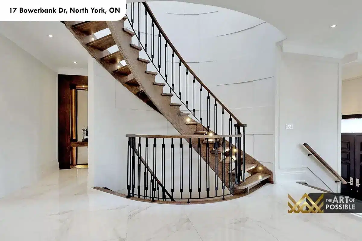 Curved walnut open-tread staircase with black iron balusters and LED step lighting at 17 Bowerbank Drive