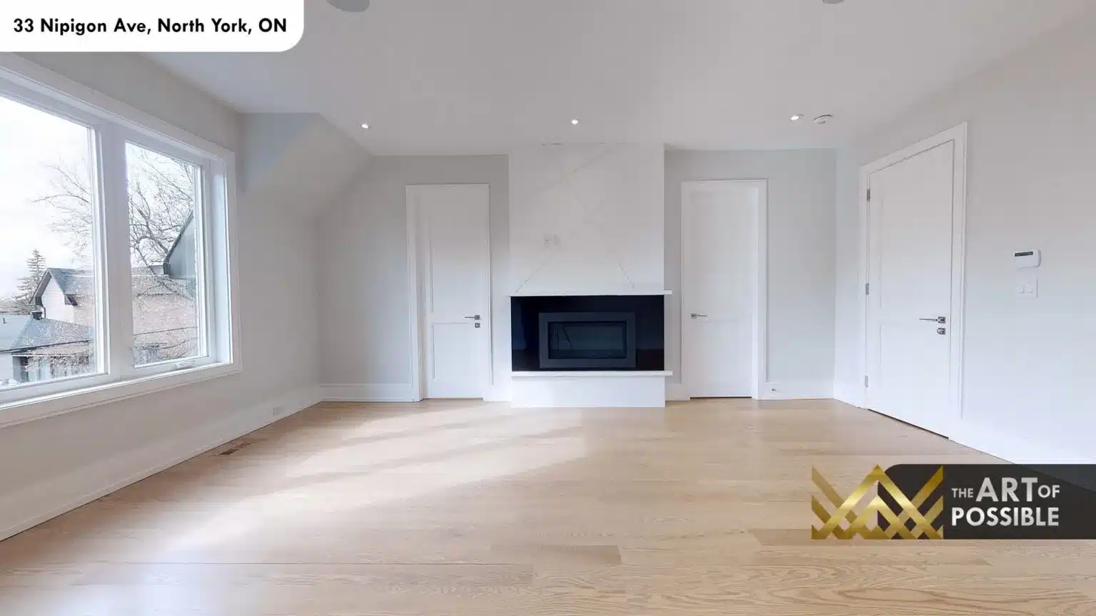 Primary bedroom with white linear fireplace and multiple doors to closet and ensuite