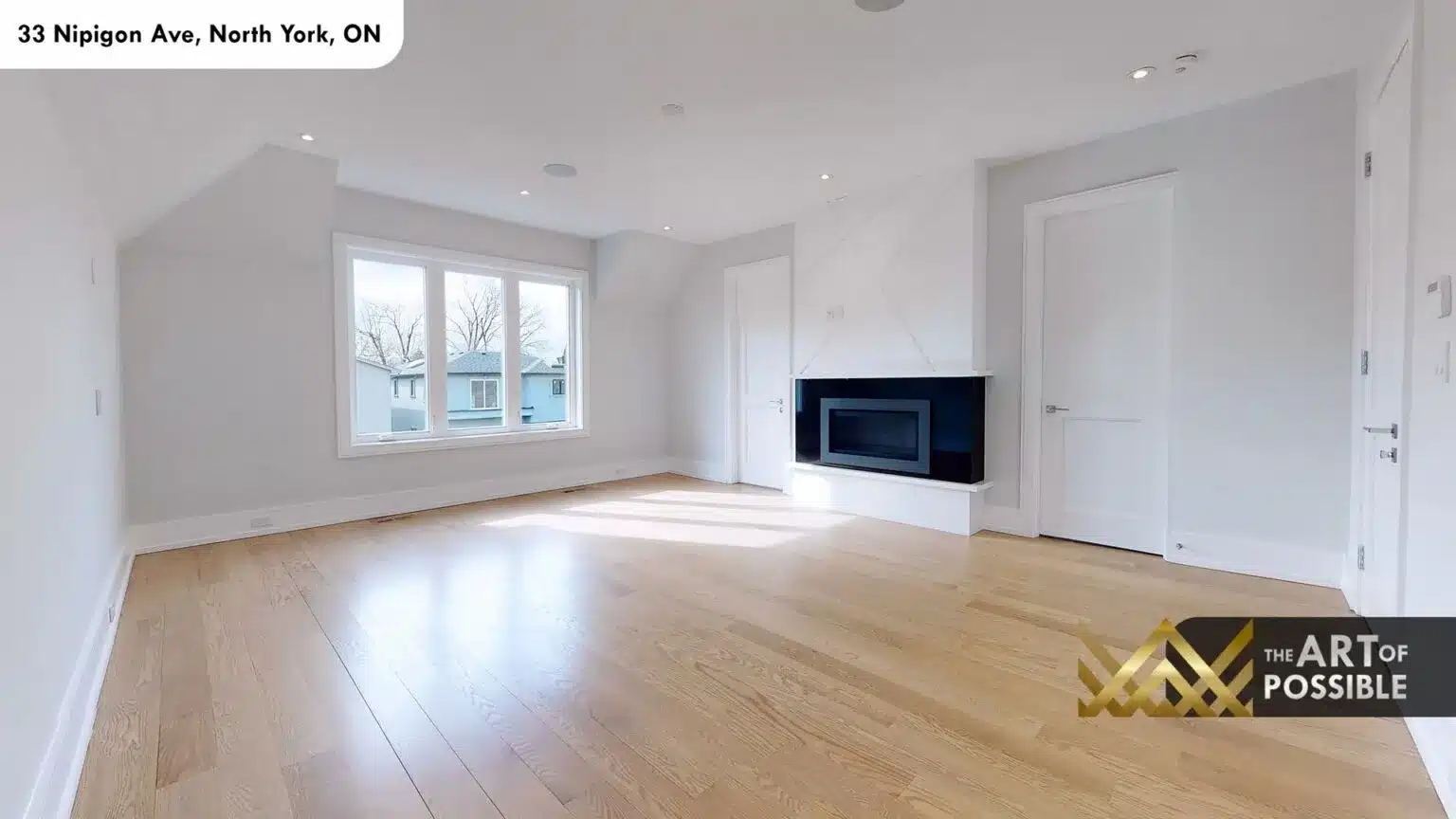 Secondary bedroom with white linear fireplace and wide-plank oak floors