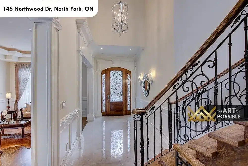 Arched wood front door with etched glass and iron staircase railing