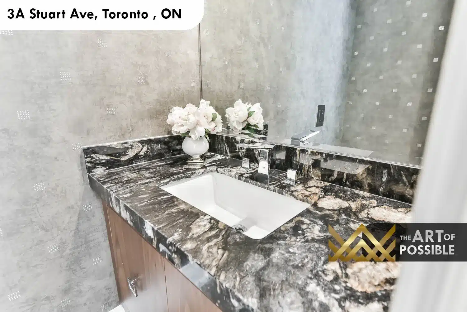 Close-up of dark swirling marble vanity top and chrome waterfall faucet in 3A Stuart Ave powder room