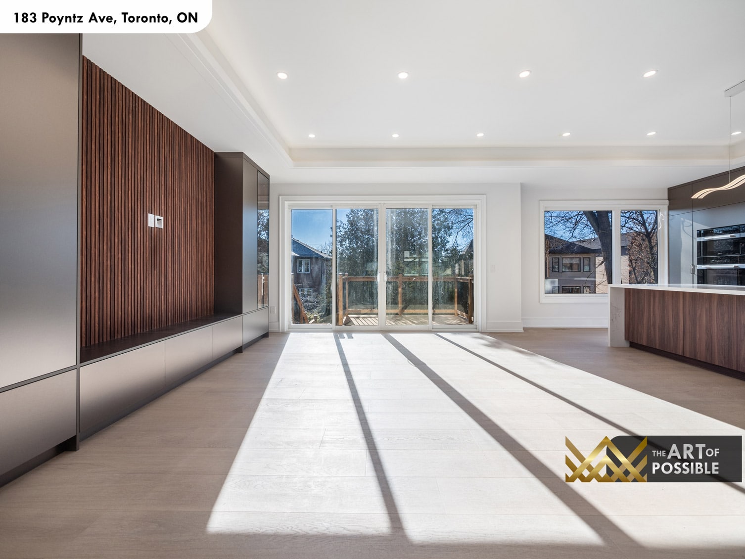 183 Poyntz Ave North York family room rear view showing walnut feature wall and sliding glass door opening to deck