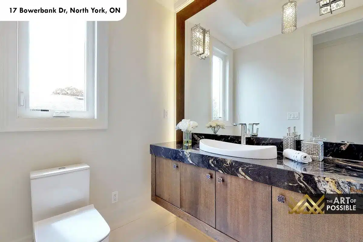 Main floor powder room with black-and-gold marble vanity top on floating walnut vanity and backlit mirror