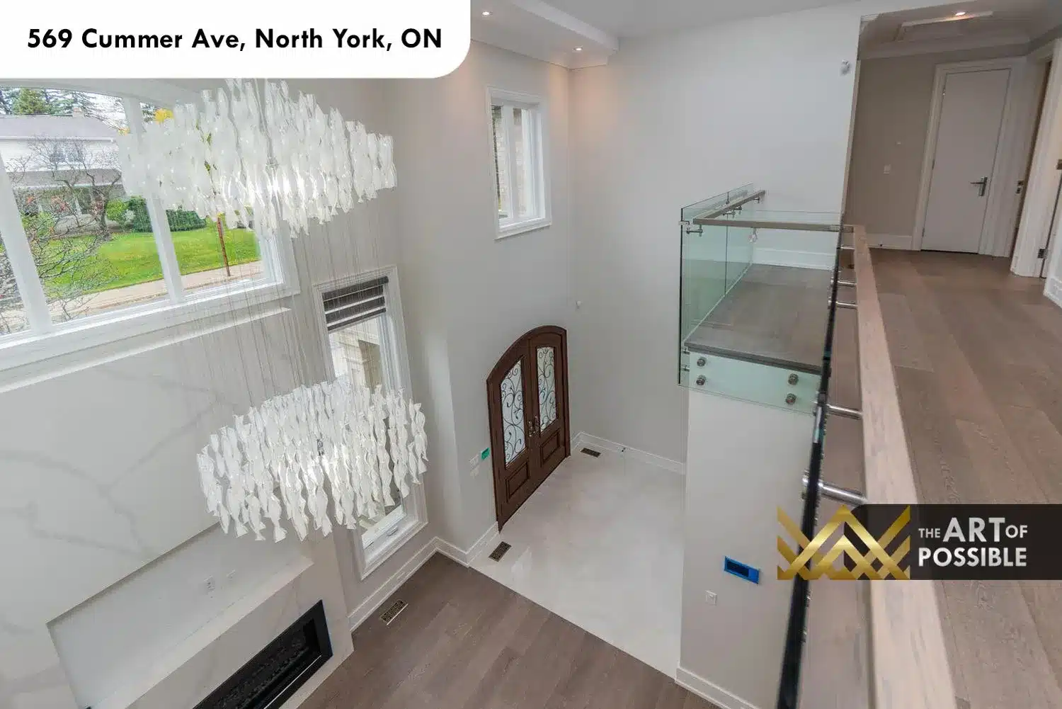 569 Cummer Ave upper landing view down to foyer walnut front door chandelier glass railing