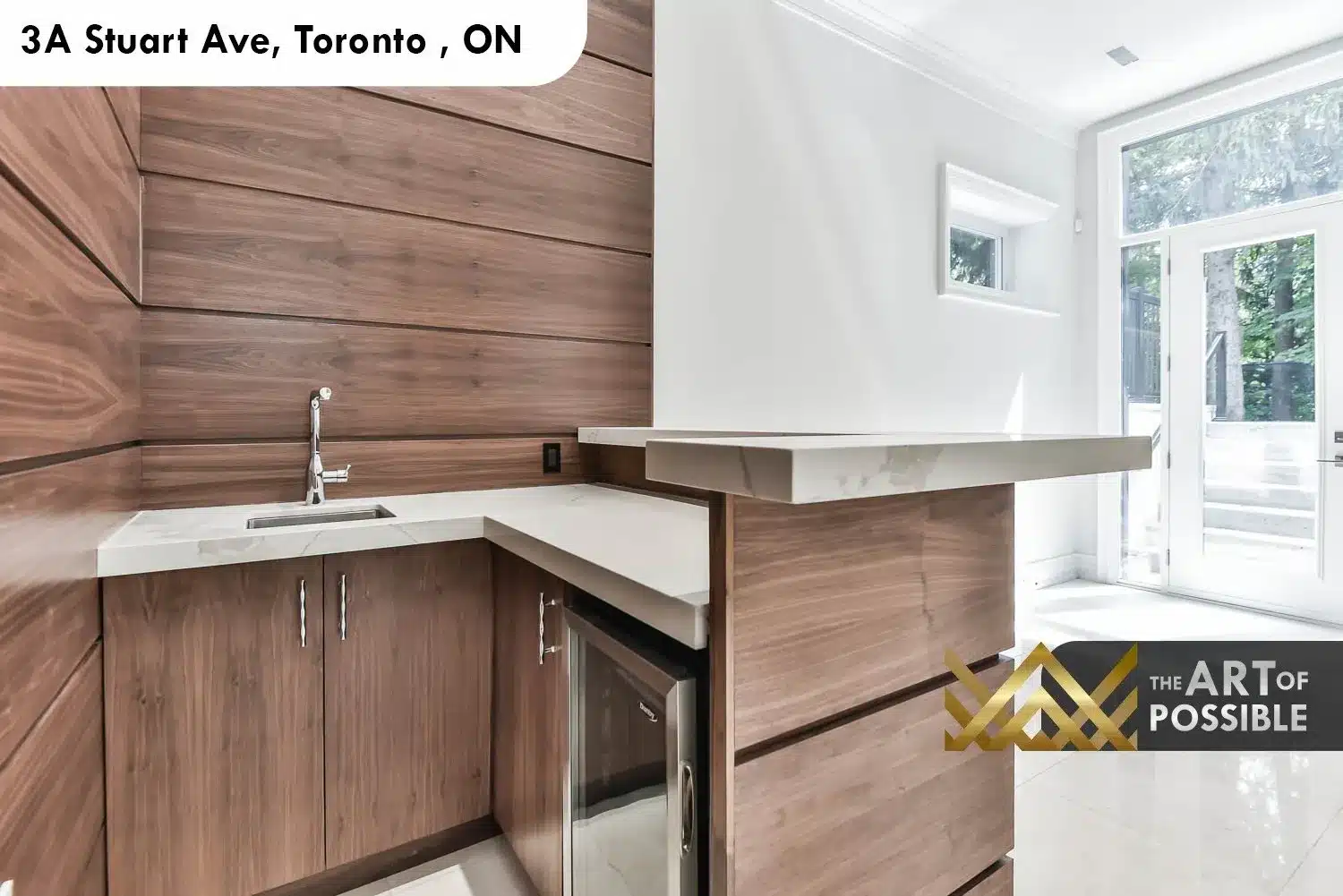 Lower level second kitchen at 3A Stuart Ave with walnut cabinetry, marble counter and walkout to exterior
