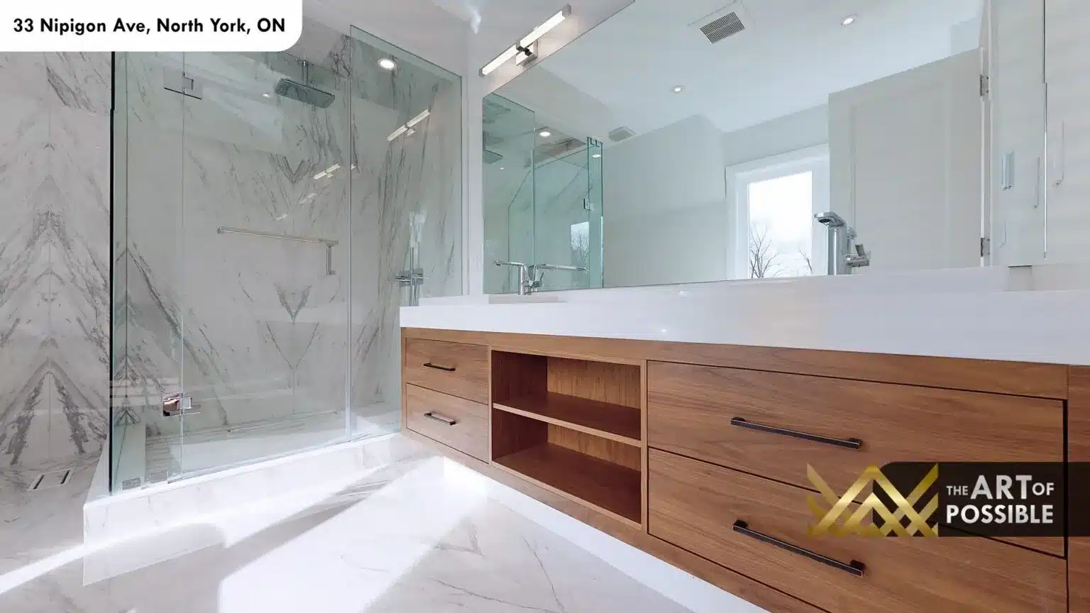 Book-matched marble shower with glass enclosure and floating walnut vanity