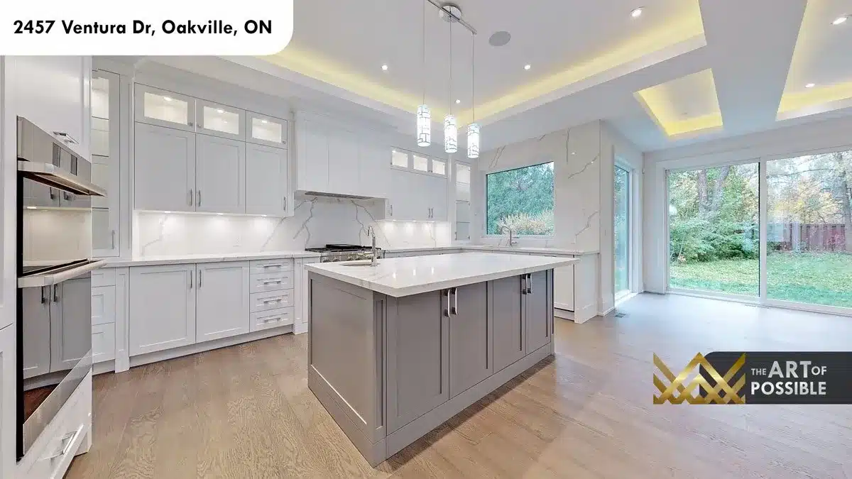 Kitchen with white shaker cabinets grey island marble slab backsplash and chrome pendants at 2457 Ventura Dr Oakville