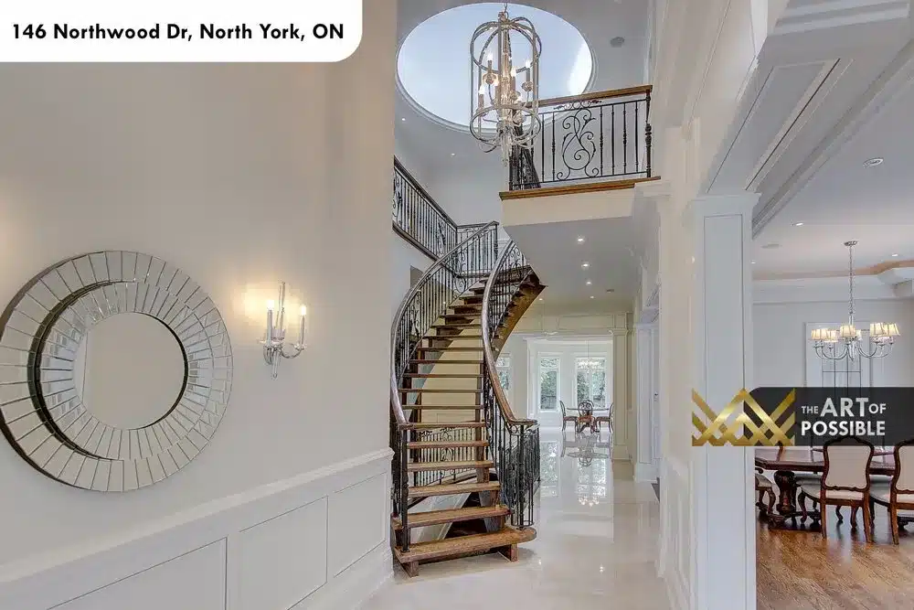 Foyer with sunburst mirror, crystal sconces and the curved staircase