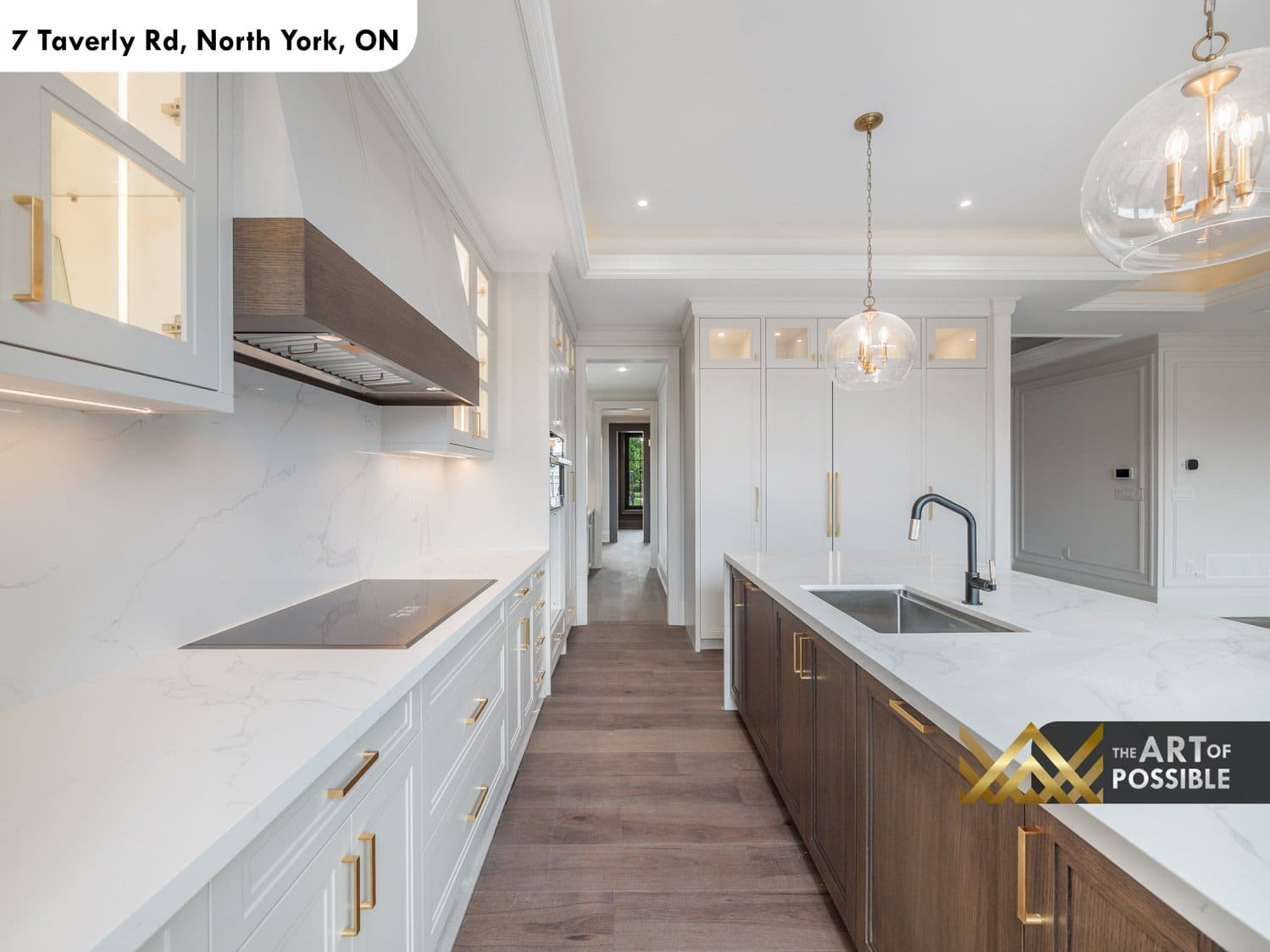 Kitchen corridor showing induction cooktop, walnut range hood and island with matte black faucet