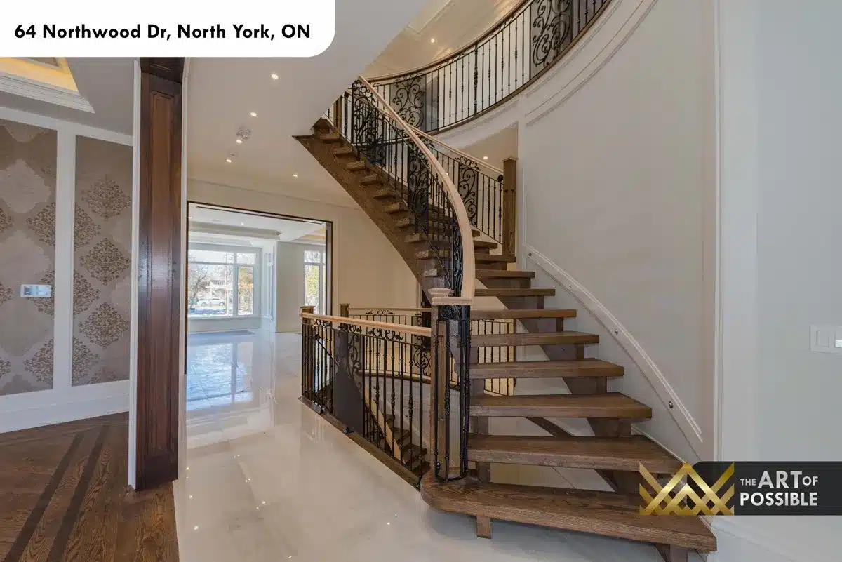 Curved oak staircase with ornate iron scrollwork balusters