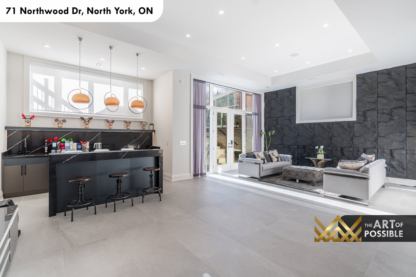 Basement overview showing wet bar, rec room seating and double French doors to yard