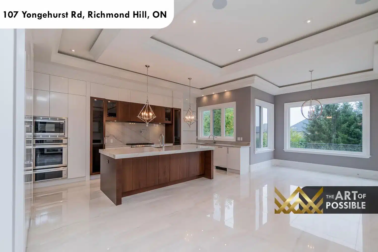Two-tone kitchen with white gloss cabinetry, walnut island, diamond pendant chandeliers and marble backsplash