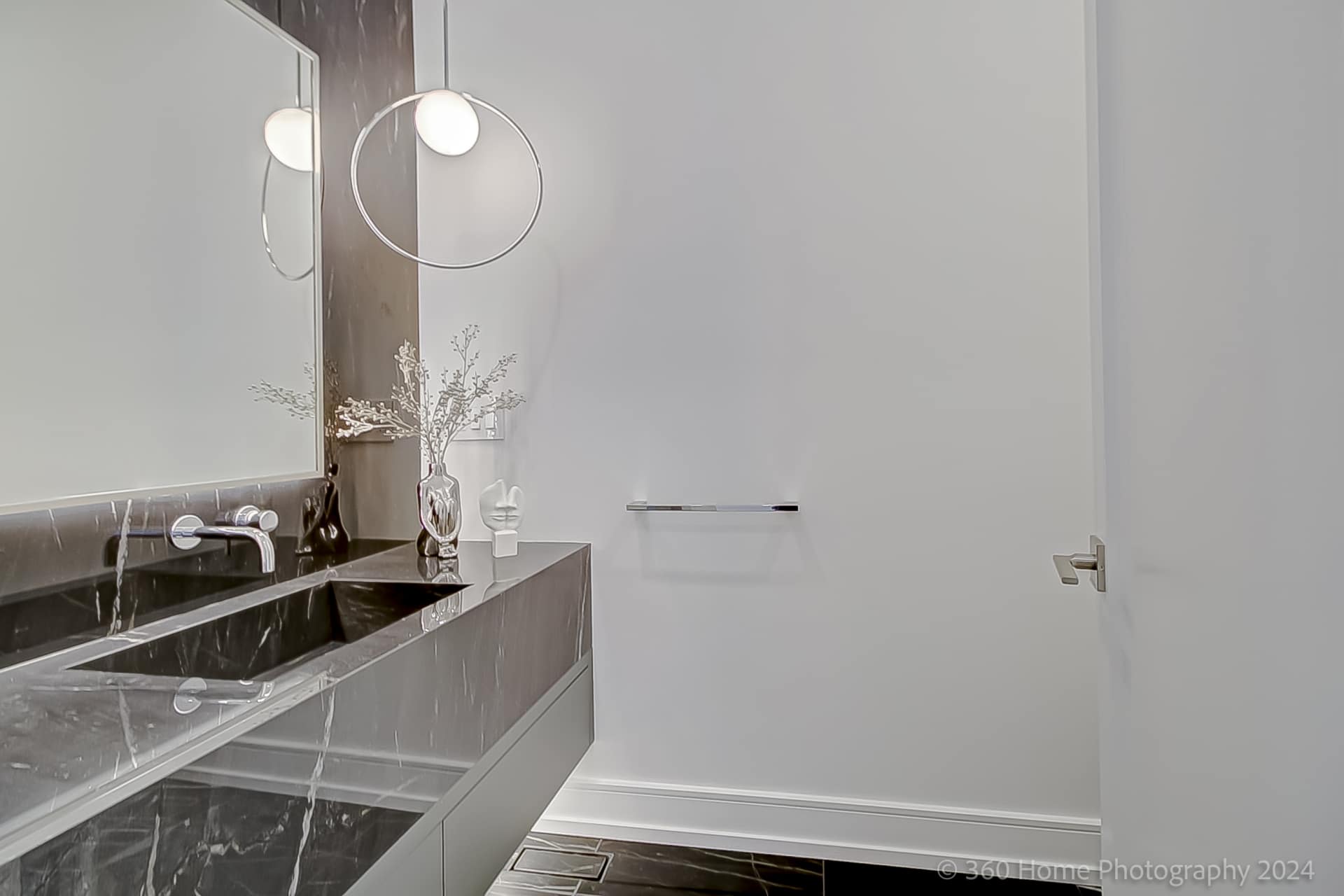 Powder room with dark marble integrated vanity and circular halo pendant at 100 Glenvale Blvd