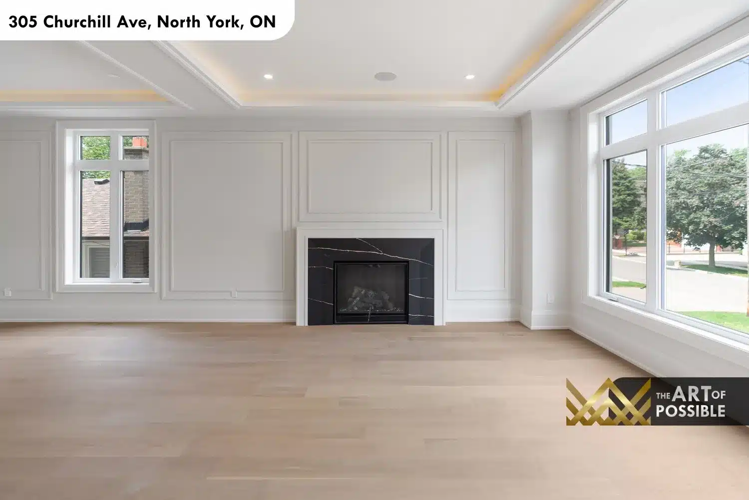 Formal living room with double coffered tray ceiling, amber LED cove lighting and black marble gas fireplace