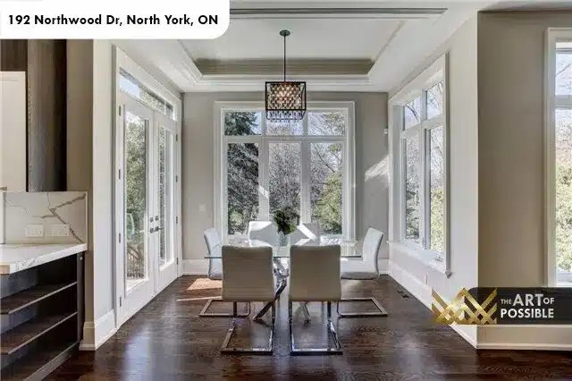Glass-wrapped breakfast nook with tray ceiling and geometric pendant light