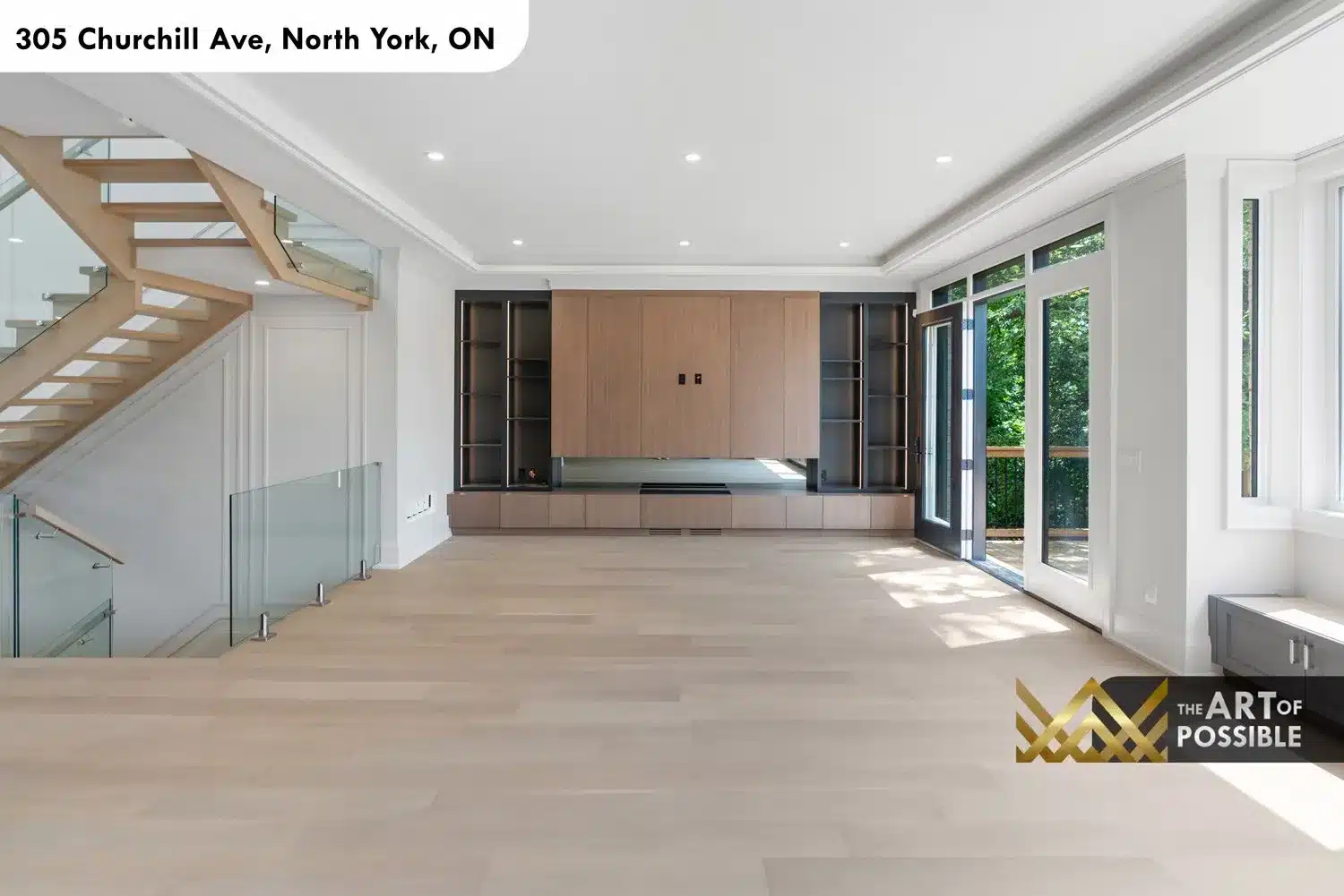 Family room with warm walnut entertainment wall, dark-framed open shelving and rear sliding glass doors to deck
