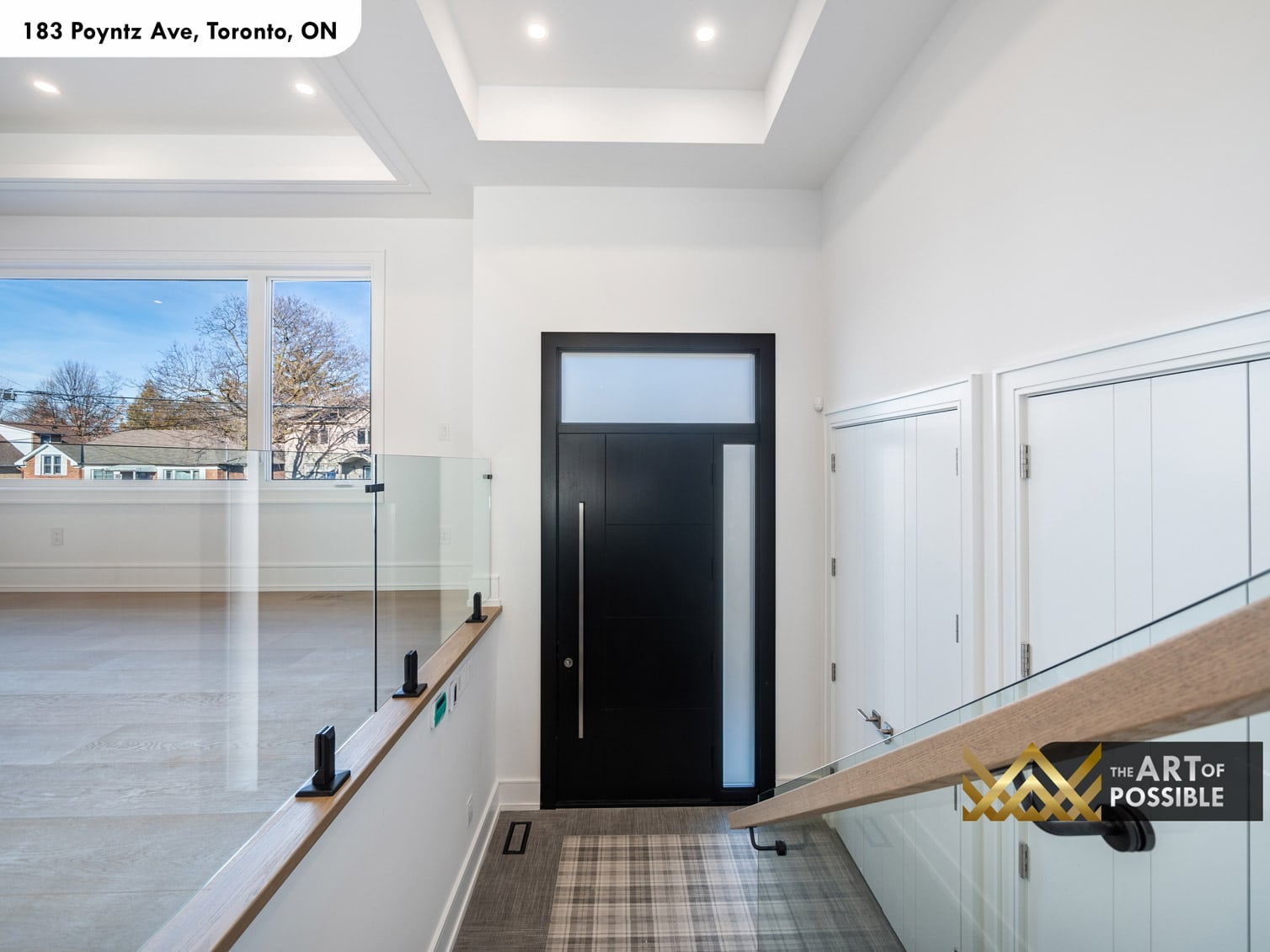 183 Poyntz Ave North York foyer with coffered tray ceiling glass panel railing and black front door with frosted sidelite