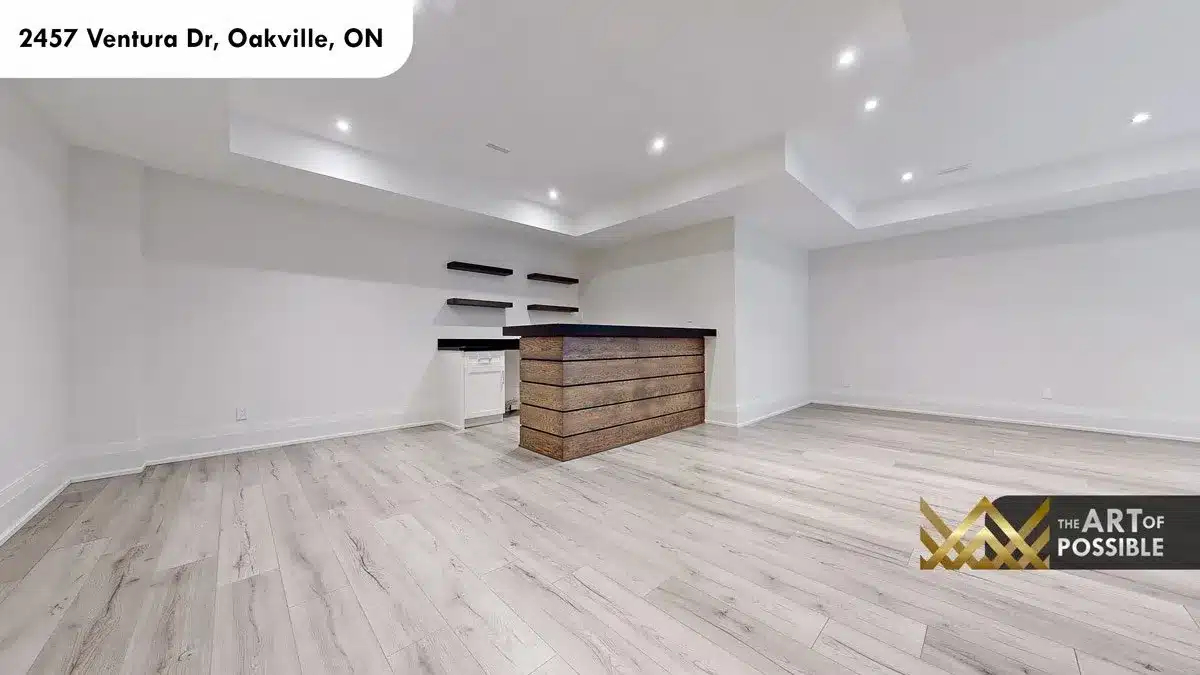 Lower level rec room with wood-plank bar front dark countertop and floating dark shelves