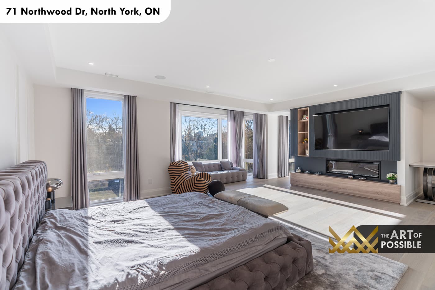 Primary suite sitting area with TV feature wall, linear fireplace and sofa lounge
