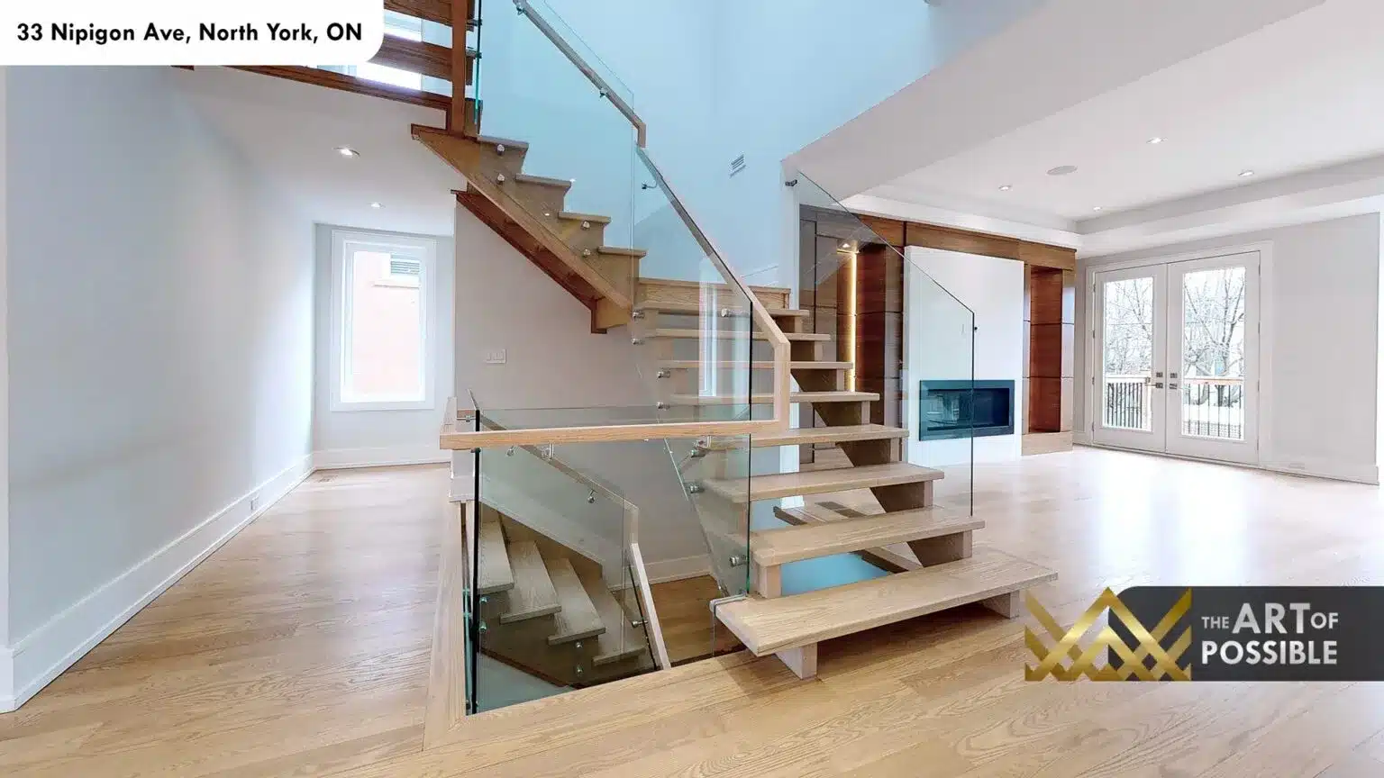 Open-tread oak staircase rising to upper floors with glass panel railings