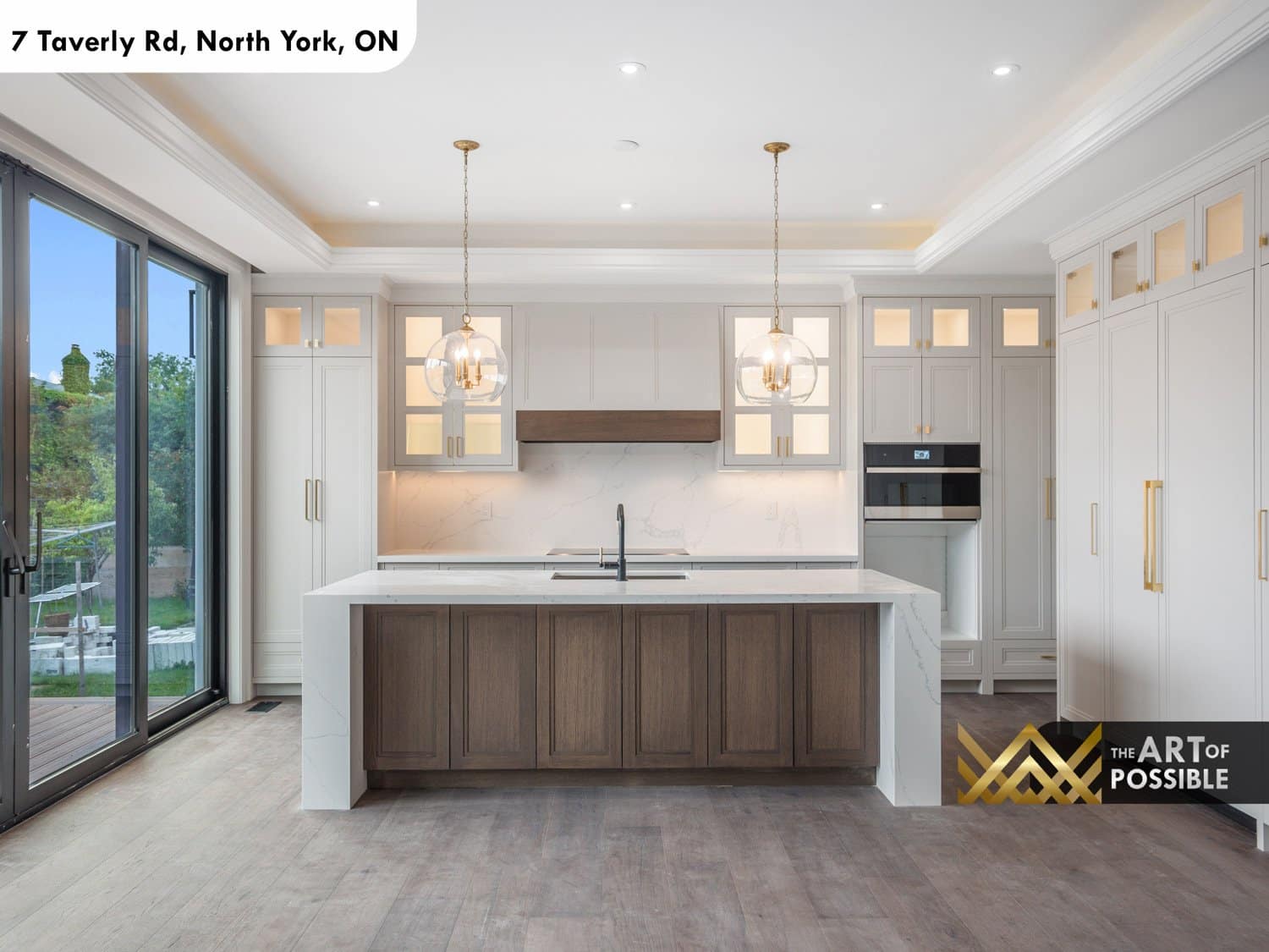 Kitchen with white shaker cabinets, walnut island, marble countertop and glass globe pendants