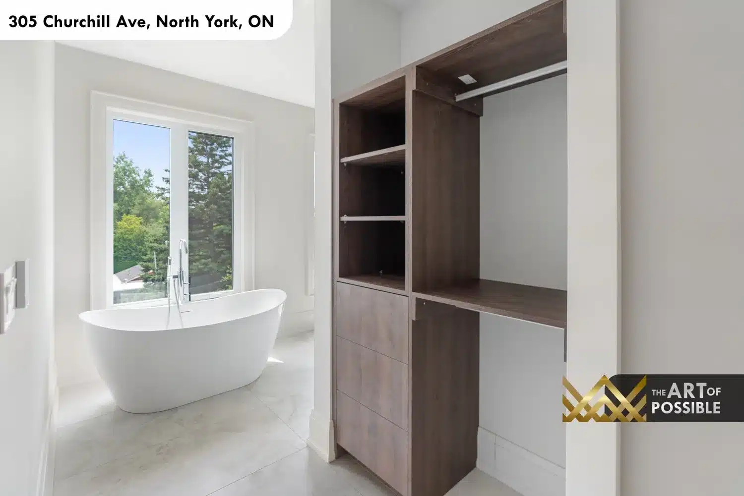Walk-in closet entry with walnut shelving unit and view through to primary ensuite freestanding tub