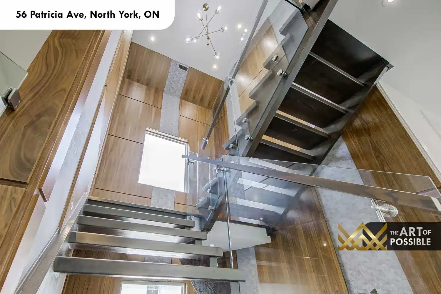 Looking up through the stairwell at 56 Patricia Ave, walnut panel walls and glass railings