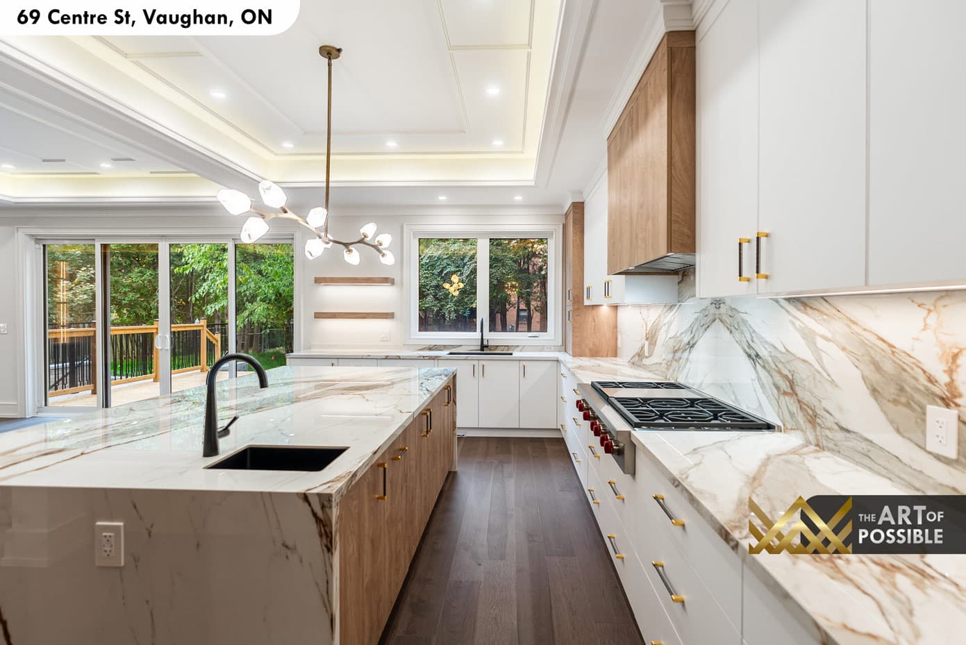 Kitchen from the rear showing marble island, walnut integrated refrigerator and sliding doors to deck