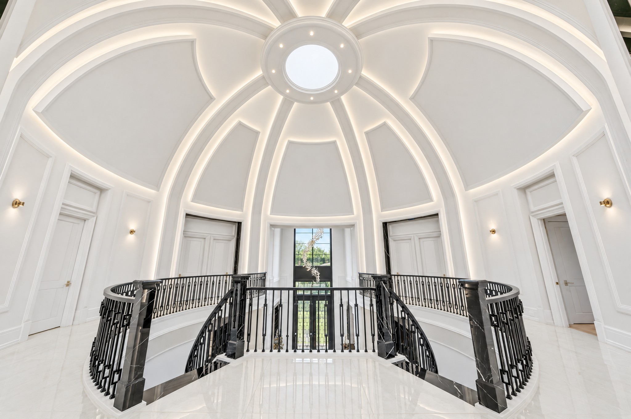 Upper floor rotunda with LED-lit plaster ribs, oculus skylight and curved iron railing