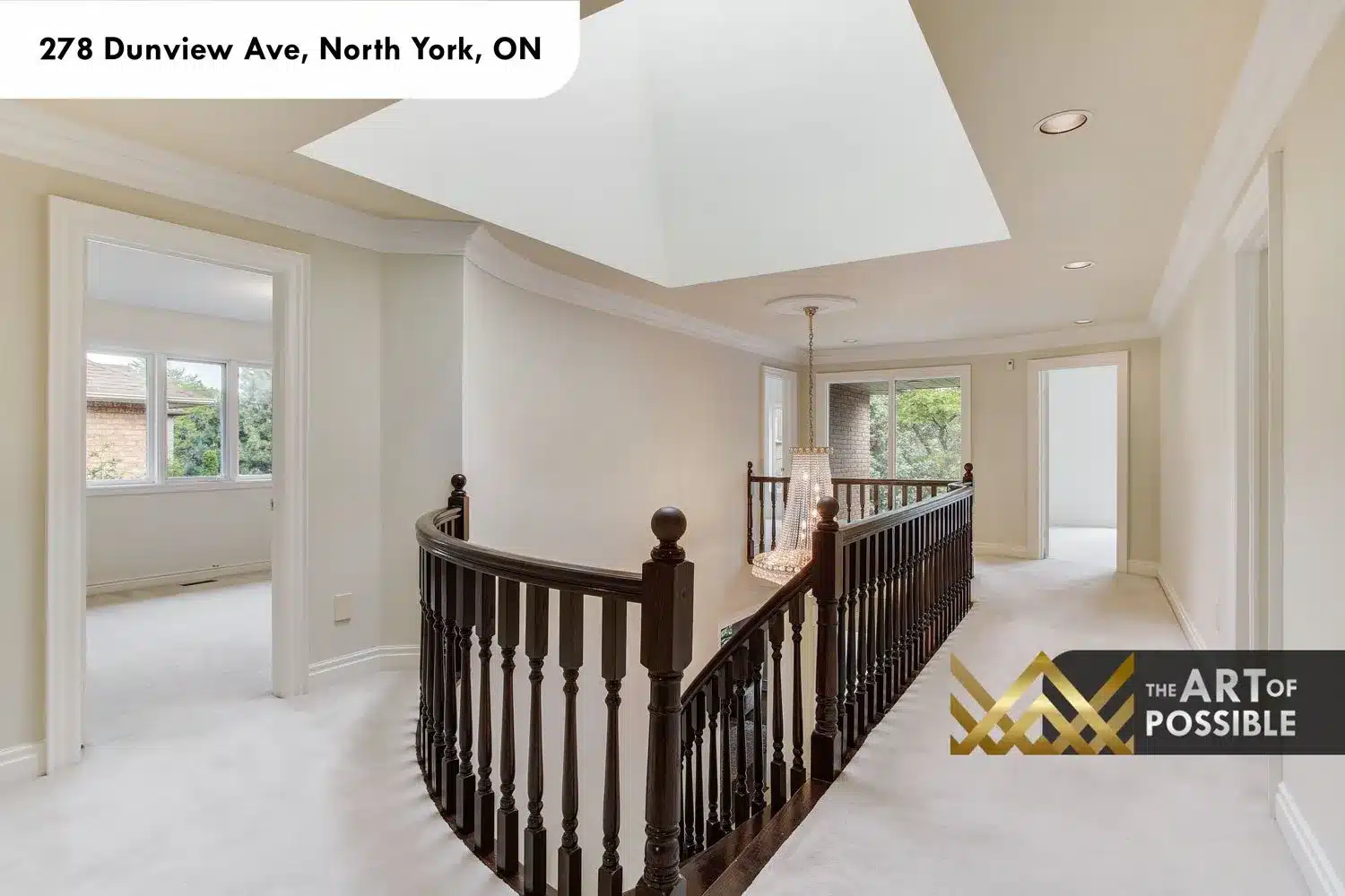 Upper landing with skylight, carpeted hall and dark-stained staircase railing