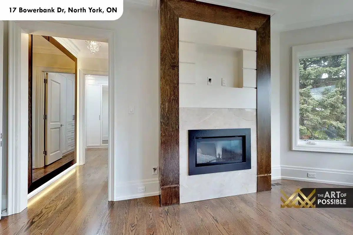 Primary bedroom linear fireplace with white marble surround in dark walnut frame