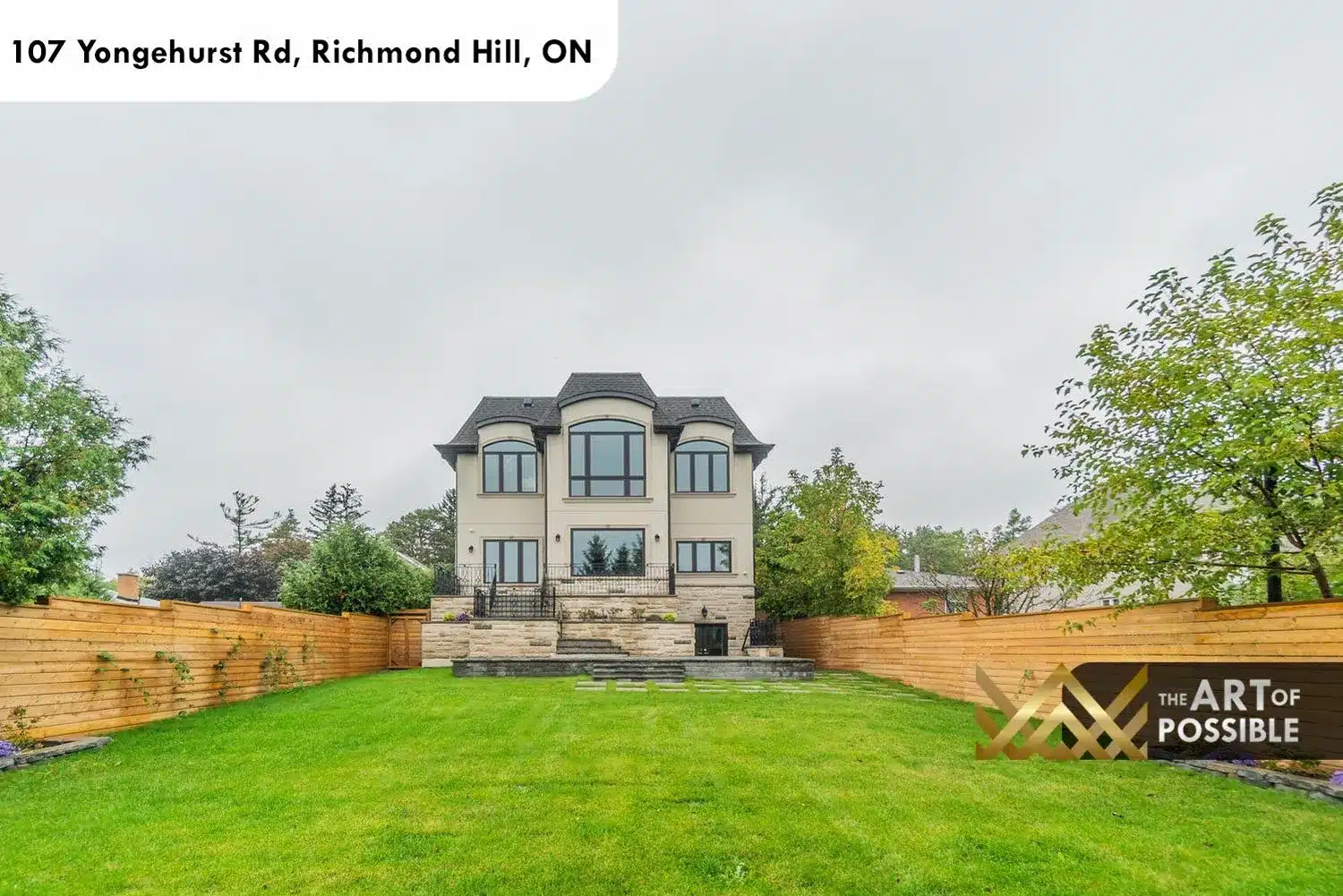 Rear exterior of 107 Yongehurst Rd with flagstone terrace, level lawn and privacy fence