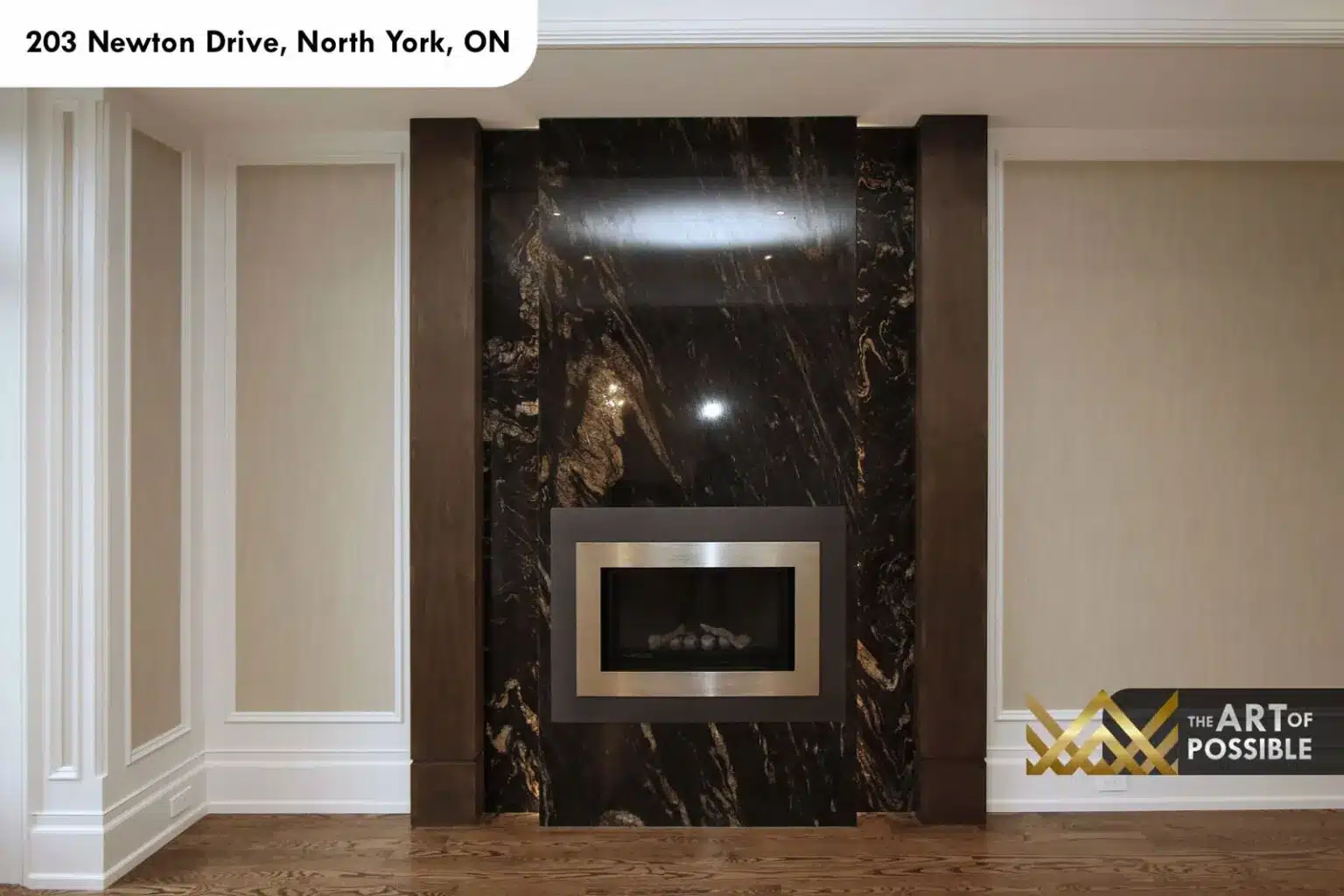 Close view of the dark marble fireplace with gold veining and stainless insert