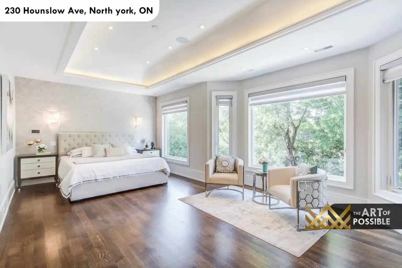 Primary suite sitting area with garden views and coffered LED ceiling