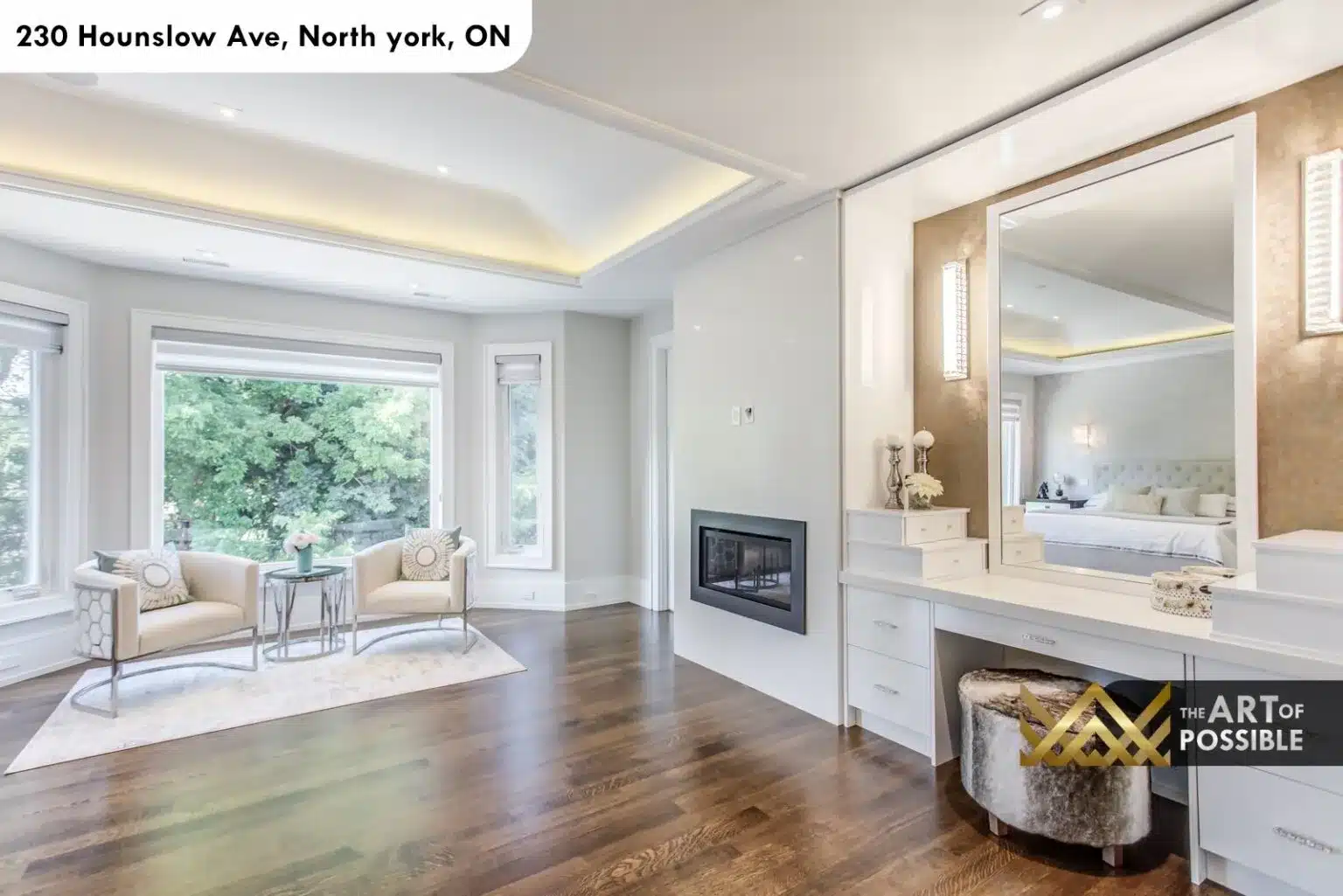 Primary suite at 230 Hounslow Ave with coffered tray ceiling, linear fireplace and makeup vanity