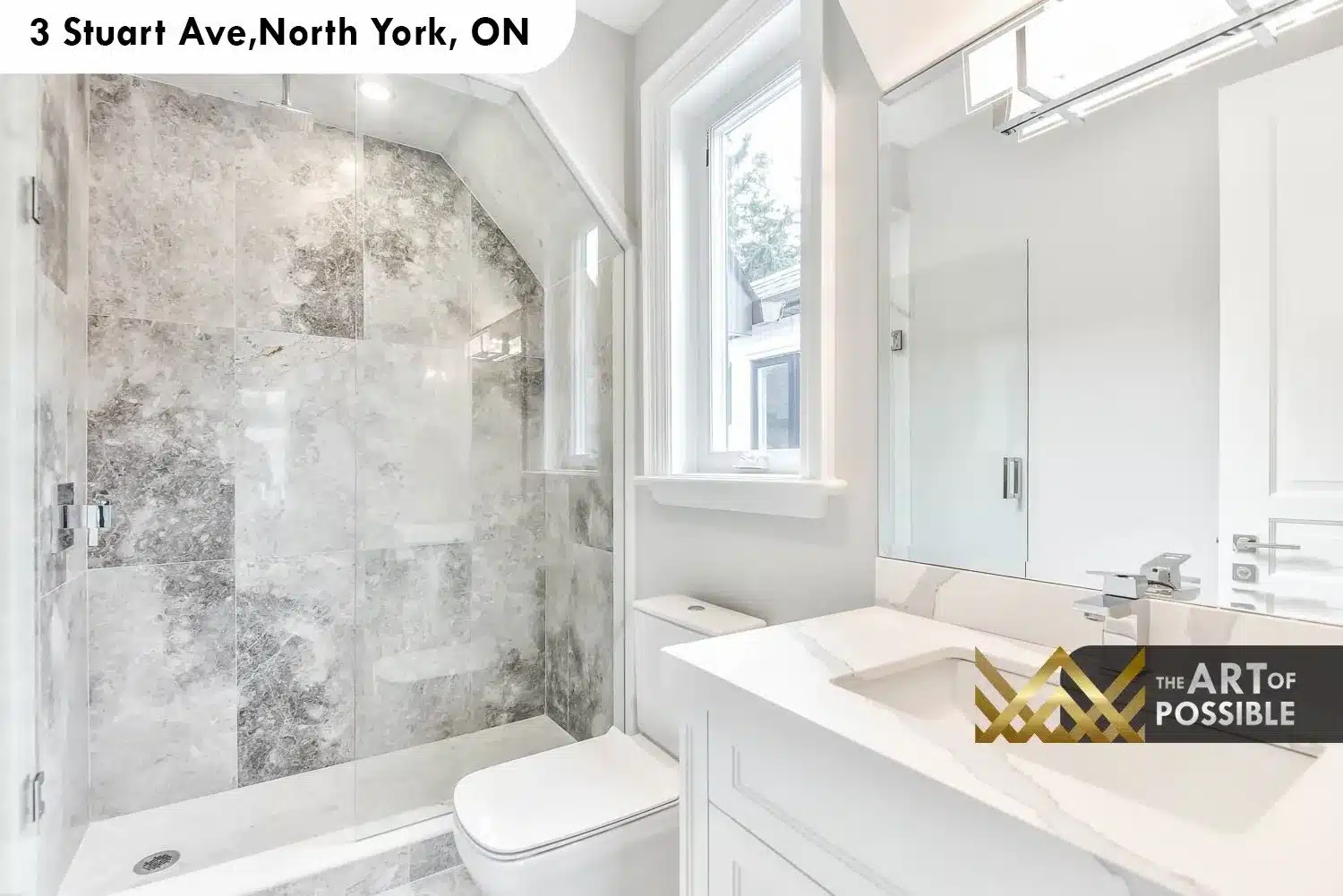 Upper floor ensuite with grey stone-tiled shower following angled roofline, white vanity and chrome fixtures