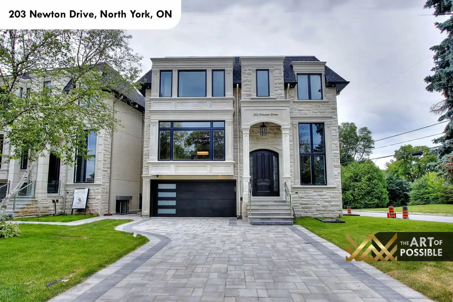 Limestone front elevation of 203 Newton Drive with double garage and arched entry