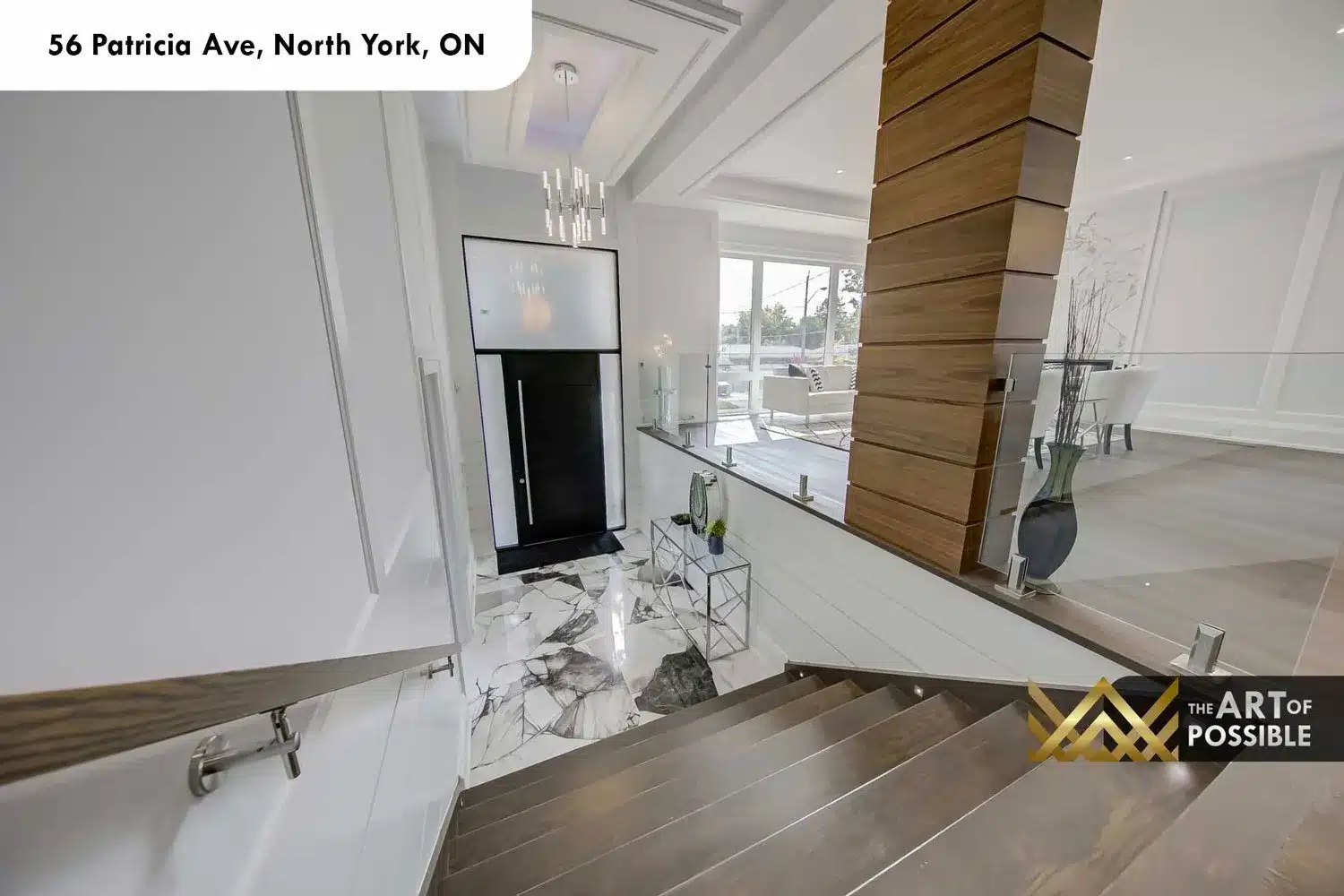 Foyer at 56 Patricia Ave showing marble tile floors, glass railings and walnut column
