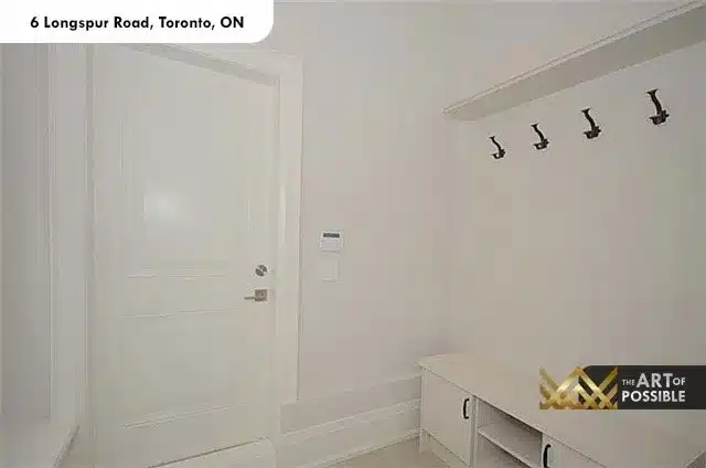 Mudroom with built-in bench storage and black iron wall hooks at 6 Longspur Rd Toronto