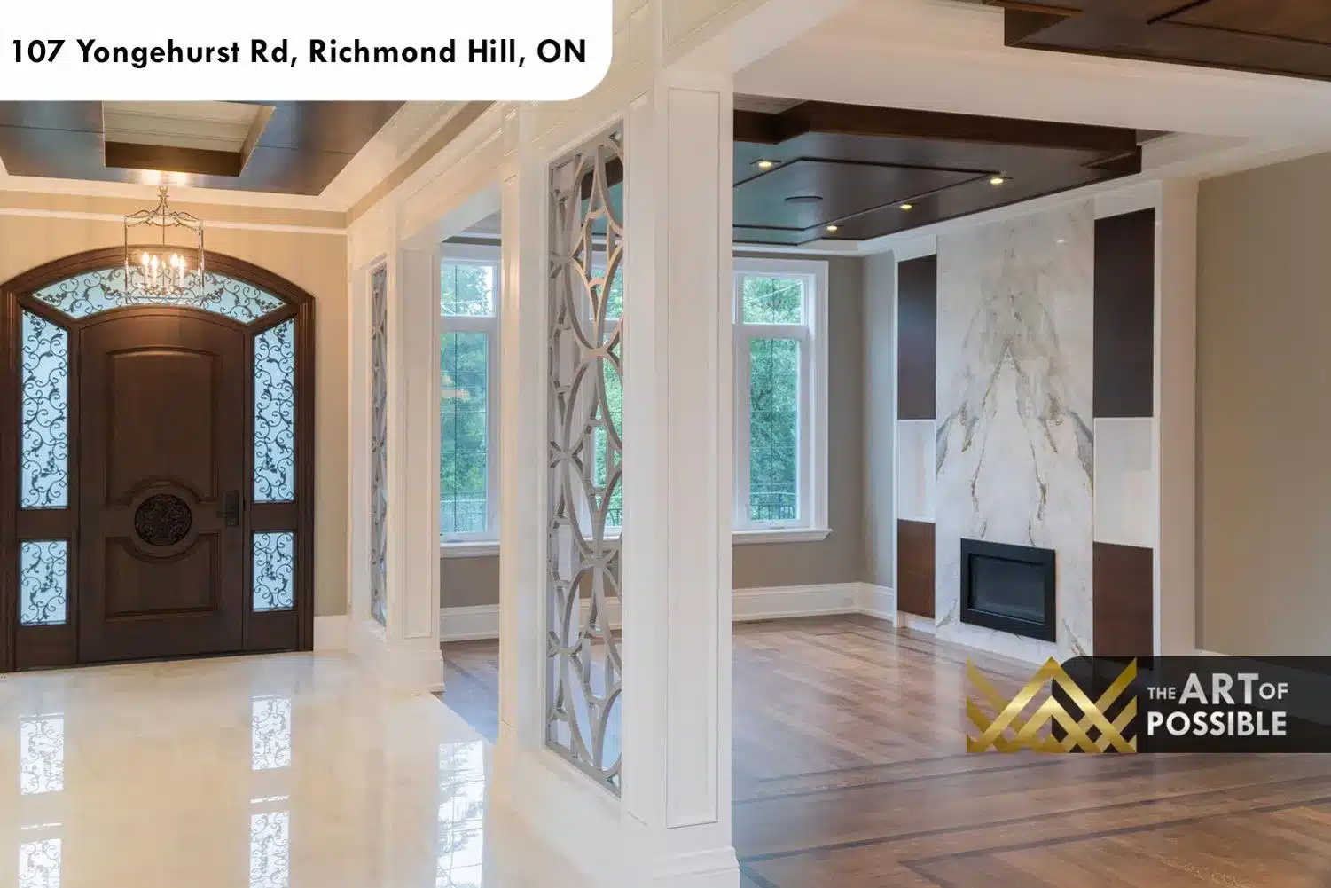 Main hallway with laser-cut geometric screen columns and view to marble fireplace in living room