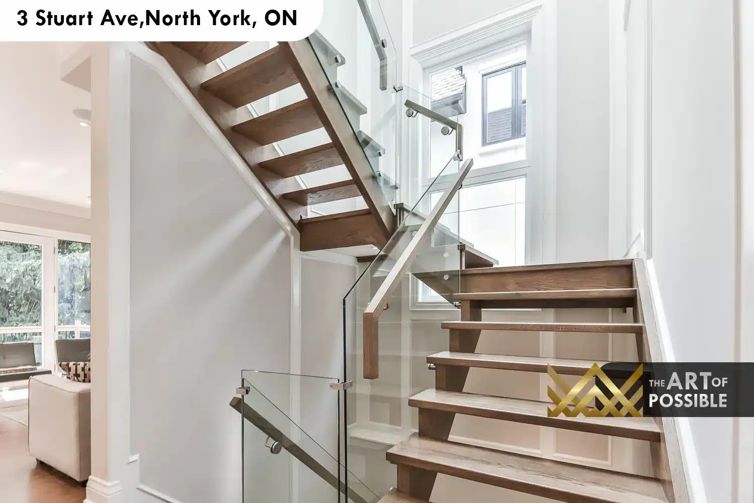 Open-tread oak staircase with full glass panel railings and tall side window
