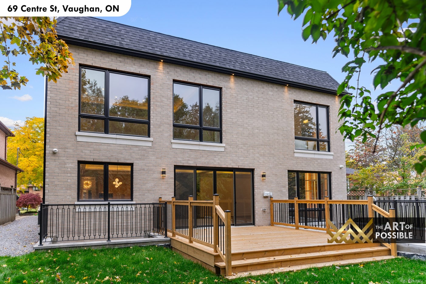 Rear elevation with sand brick cladding, natural wood deck and black iron railings