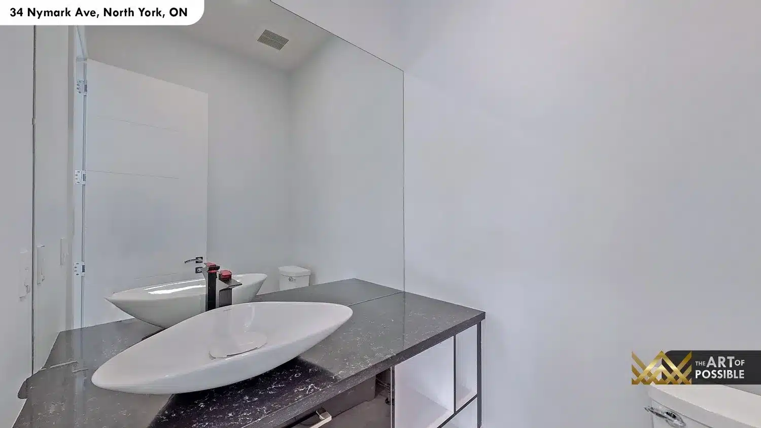 Primary ensuite - double white oval vessel sinks on dark veined stone countertop with matte black faucets and full-height frameless mirror